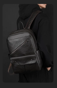 Detailed view of the dark brown PU leather backpack with side pockets and smooth texture