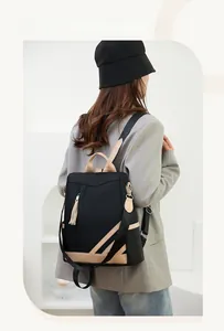 Detail of contrast PU leather backpack with anti-theft back opening and tassel charm