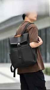Detail of waterproof black backpack with metal buckle and orange leather handle accents