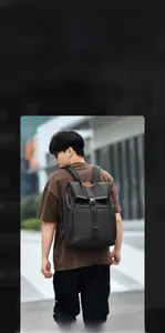 Detail of black commuter backpack with durable fabric and contrasting orange top handle