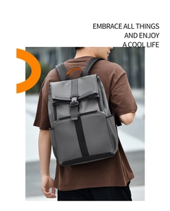 Detail of grey roll-top commuter backpack with orange handle and waterproof fabric
