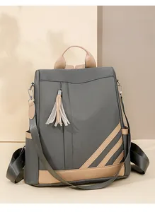 Detail view of grey PU leather backpack with contrast trim and tassel accessory