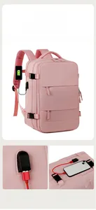 Pink travel backpack detail showing integrated USB charging port and side buckle strap