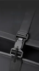 Detailed macro view of the front magnetic buckle on the black business backpack