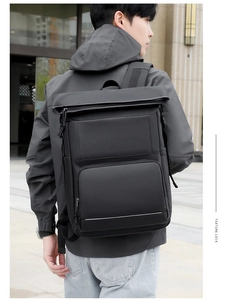 Detail of waterproof matte black backpack with ergonomic straps and flap closure on male model
