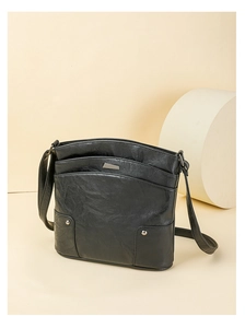 Detail of black PU leather shoulder bag featuring multi-layer zippers and metal rivets