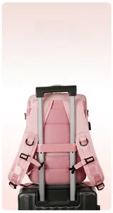 Pink nylon backpack detail showing the back luggage strap attached to a suitcase handle