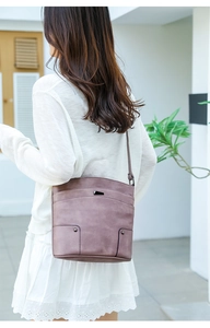 Detail of vintage layered PU leather crossbody bag in dusty rose with metal hardware