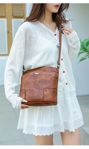 Close-up of vintage brown PU leather crossbody bag with metal geometric hardware detail
