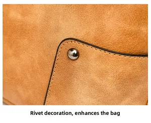 Detail of tan suede fabric with silver studs and precise stitching on women shoulder bag