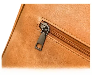 Detail of premium brown faux leather texture and smooth dark metal zipper closure