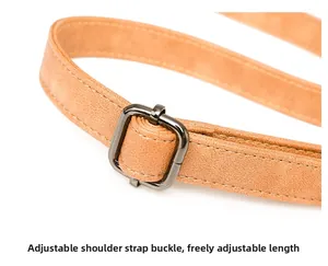 Detail of adjustable camel faux suede shoulder strap with dark stitching and gunmetal buckle