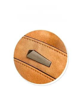 Detail of vintage orange-brown faux leather bag with brushed dark grey metal hardware