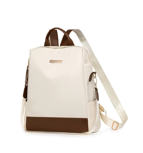 Détail du sac à dos en tissu Oxford beige avec bordure en cuir marron et boucles dorées