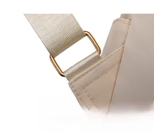 Détail de la boucle en métal doré et de la sangle en nylon beige du sac à dos chic