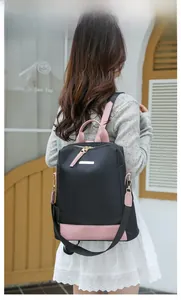 Vue arrière d'un sac à dos élégant en tissu Oxford noir et rose porté par un modèle