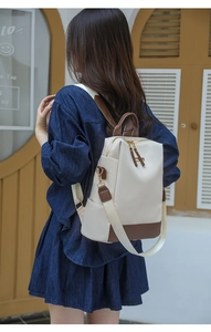 Sac à dos chic en nylon beige et cuir marron porté par un mannequin de profil