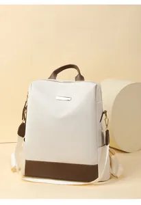 Détail du sac à dos en oxford montrant le fond en cuir contrasté et les finitions métalliques