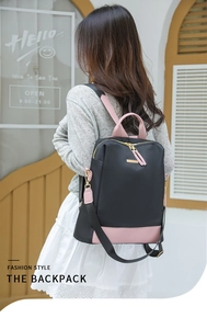 Détail d'un sac à dos en nylon noir avec cuir rose contrasté et garnitures dorées