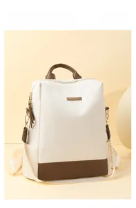 Détail d'un sac à dos en tissu Oxford crème et marron avec finitions en cuir