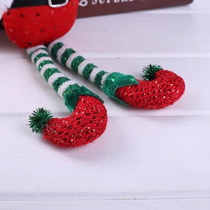 Christmas elf doll legs with red sequin shoes and green white striped knitted stockings
