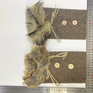 Detail of fishbone pattern fabric boot covers with faux fur trim and wooden buttons