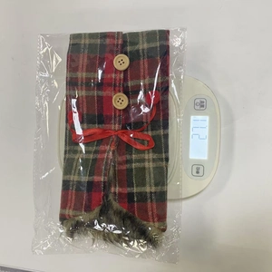 Detailed view of 27g red plaid Christmas wine bottle cover with fur trim and buttons