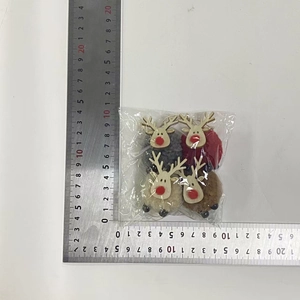 Close-up of four plush Christmas reindeer ornaments in grey, red, beige and brown
