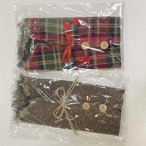 Detail of plaid Christmas wine bottle covers with fur collars and wooden buttons
