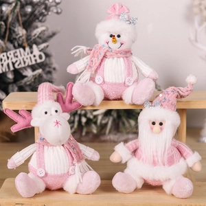 Pink plush Christmas dolls with sequins and knit sweaters in festive scene