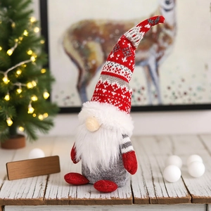 Detail von Weihnachtsgnom-Plüsch mit gestrickter Schneeflockenmütze auf rustikalem Holztisch