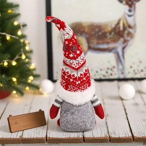 Detail eines Weihnachts-Wichtels mit roter Schneeflocken-Strickmütze und weißem Kunstpelz