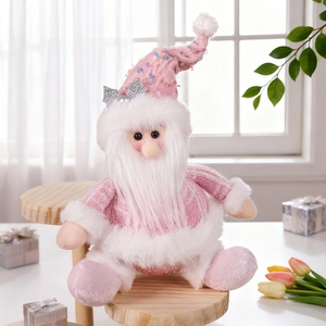 Close-up of pink Christmas doll with sequined hat and knitted outfit in cozy setting