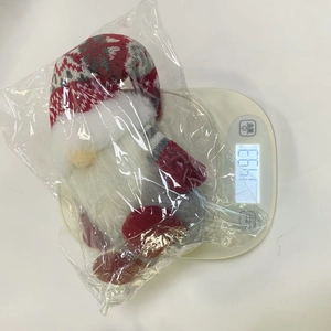 Weihnachtswichtel verpackt auf einer Waage mit Anzeige von 149,3g Gewicht