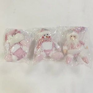 Close-up of pink Christmas plush ornaments with sequins and knitted details in set