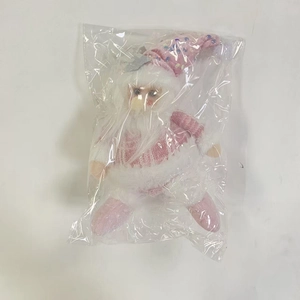 Detailed view of pink Christmas gnome plush with sequined hat in clear package