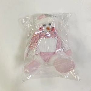 Close-up of pink snowman plush with striped hat and sequin scarf in festive style