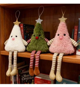 Three plush Christmas tree dolls with long legs sitting on a wooden festive shelf