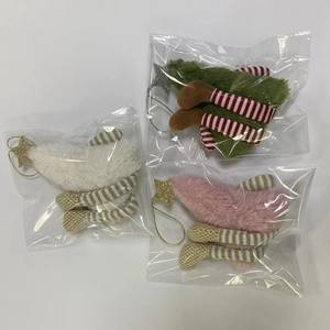 Detailed view of plush Christmas tree ornaments with sequins and striped legs in polybag