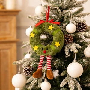 Plush Christmas wreath ornament with star, bow, and striped legs on a festive tree branch