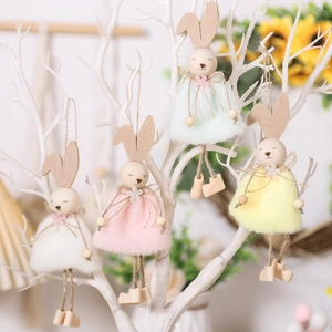 Detailansicht von vier bunten Plüsch-Osterhasen an weißen dekorativen Zweigen aufgehängt