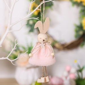 Handgefertigter Osterhase aus Holz mit Filzohren und rosa Kleid an weißen Zweigen