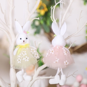 Easter bunny plush pendants in floral dresses hanging on white decorative branches