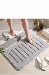 Detail of grey absorbent microfiber bath mat with vertical striped texture in bathroom setting