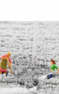 Detailed macro view showing rapid water absorption on thick grey microfiber bath mat
