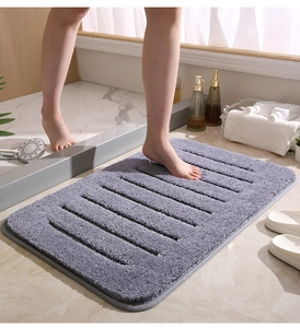 Primer plano de alfombra de baño gris de felpa con rayas para absorción de agua