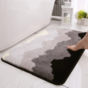 Tappeto da bagno assorbente in peluche con onde grigie su pavimento in marmo