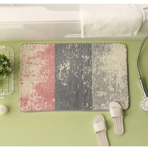 Detail of plush tricolor bathroom rug featuring pink and grey absorbent shaggy textures