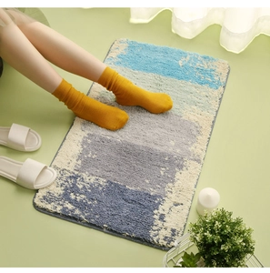 Detail view of plush geometric bathroom mat with blue grey and beige color blocking style