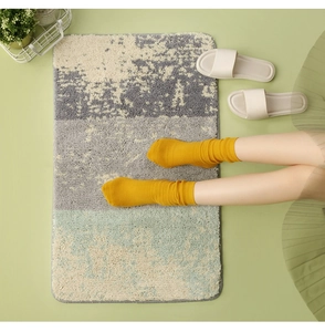 Macro detail of plush absorbent bath mat with gray and green abstract textured patterns